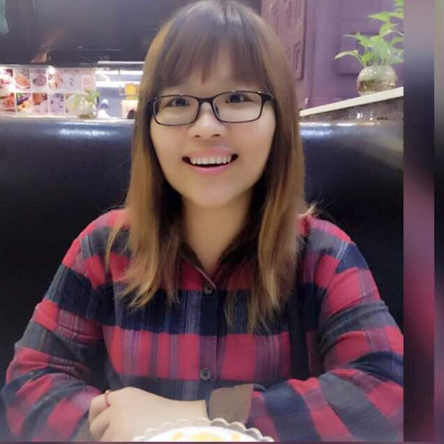 Elfglass founder Ava Zeng smiling with glasses in red plaid shirt at cafe