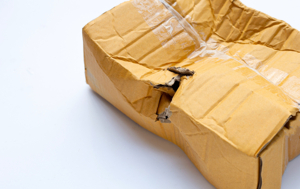 Damaged shipping box illustrating a common root cause of glass pipe returns