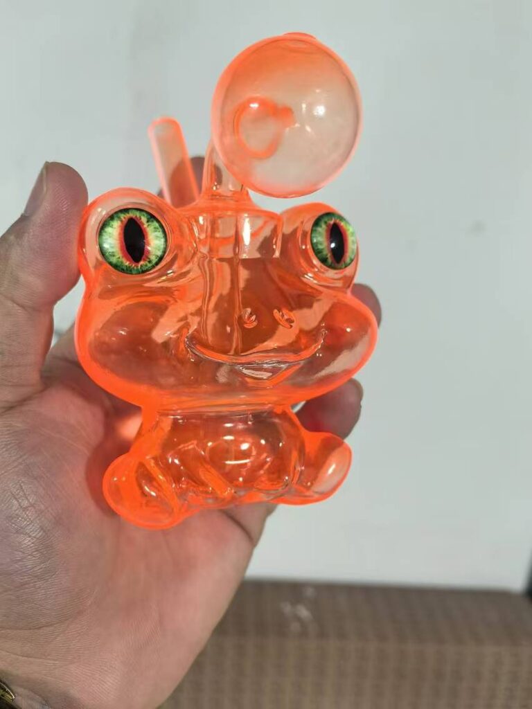 Orange frog-shaped glass bong held in hand