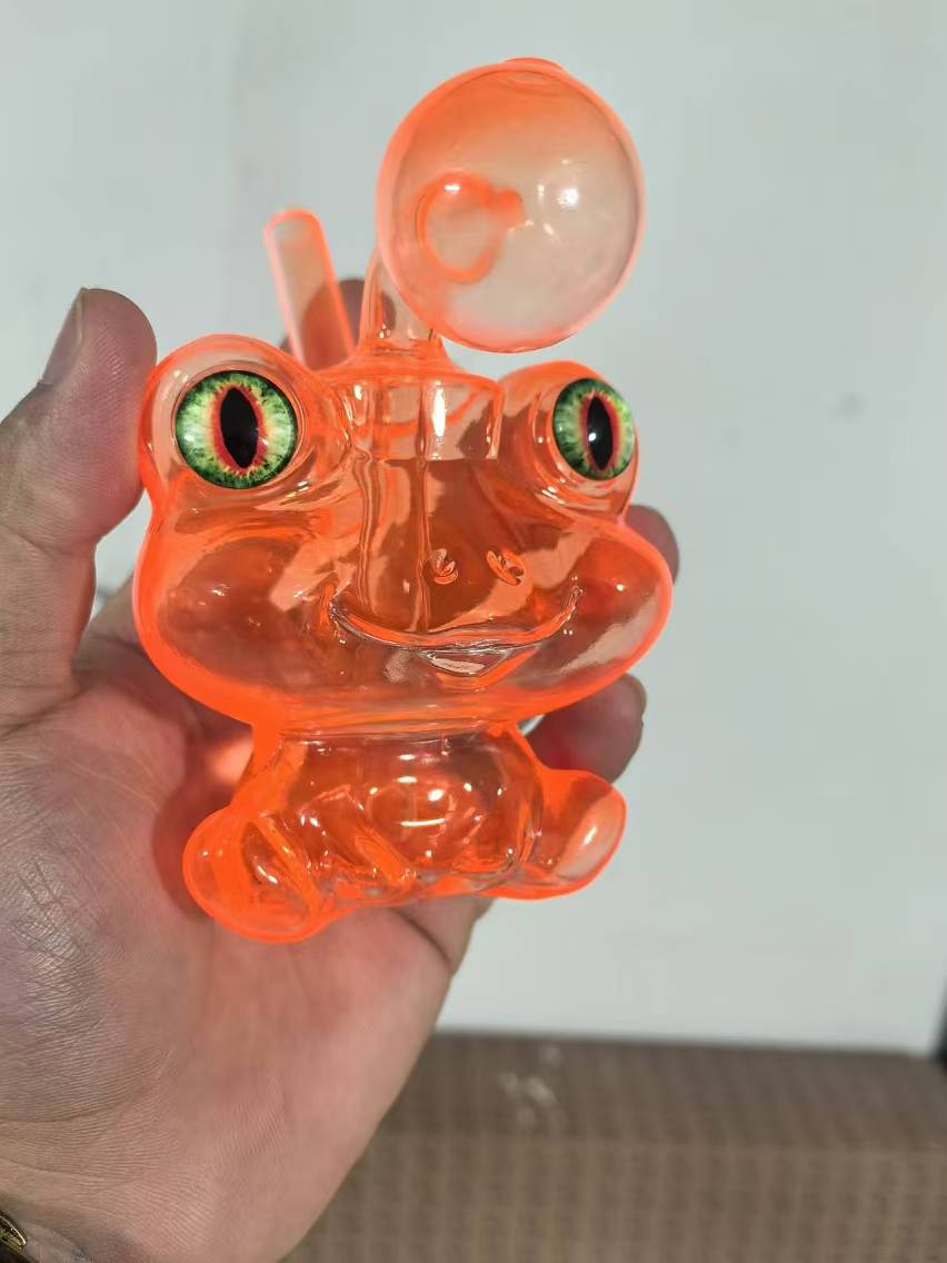 Orange frog-shaped glass bong held in hand