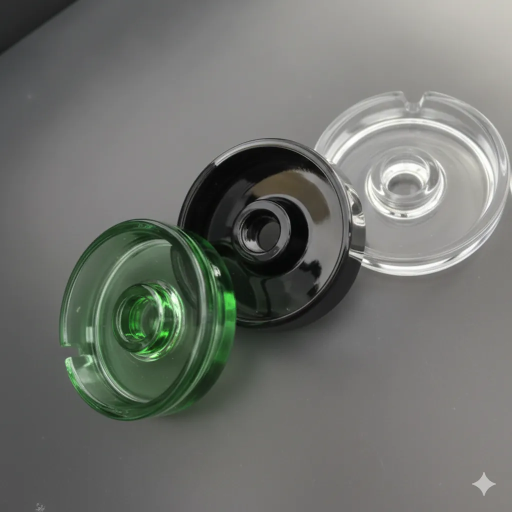 Green black and clear glass ashtray lids with center holes on gray surface