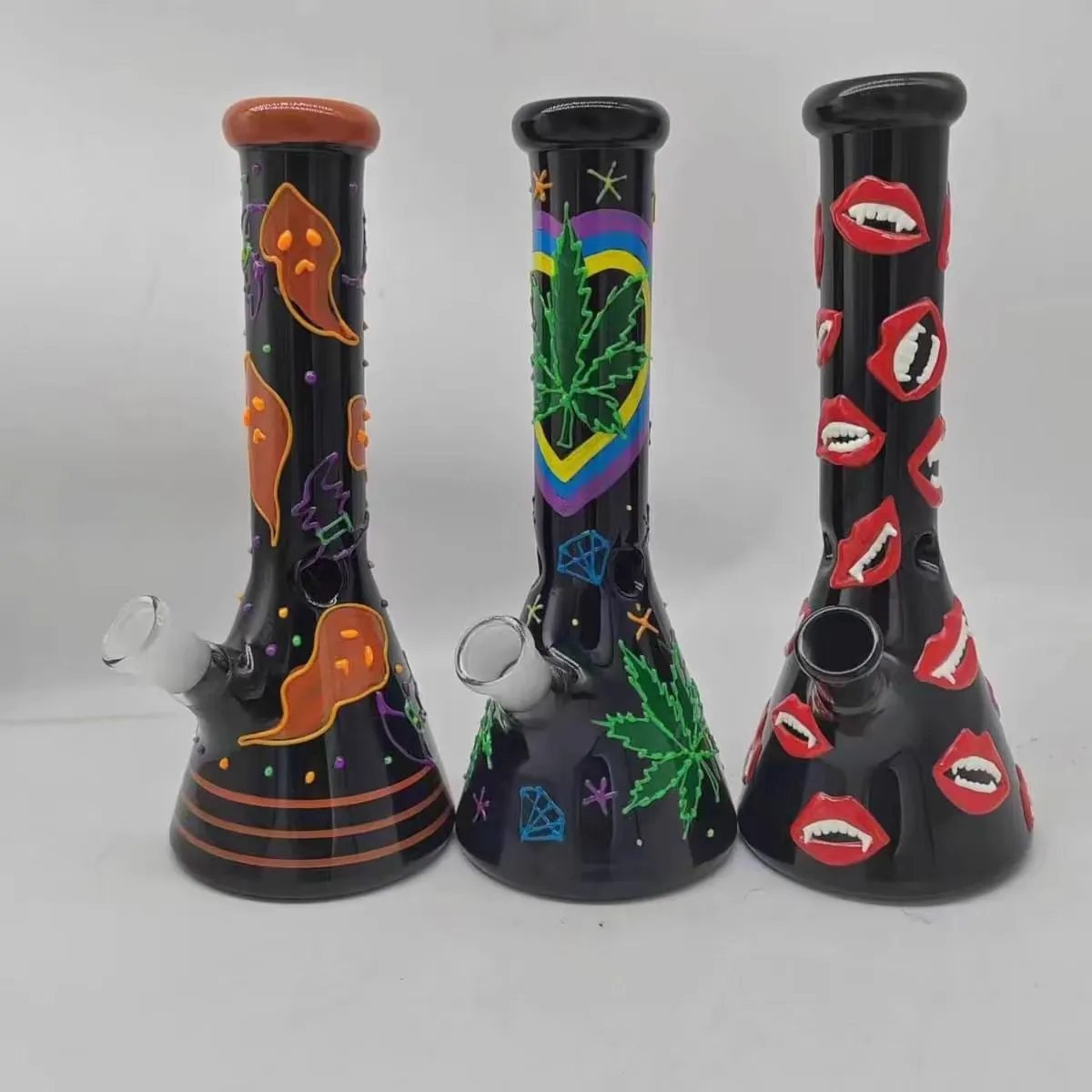 Three matte black glass bongs decorated with Halloween ghosts bats vampire lips