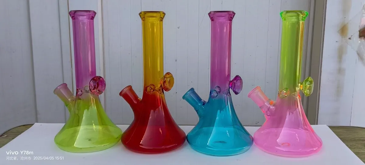 Four gradient glass bongs in green purple red yellow blue and pink arranged on white