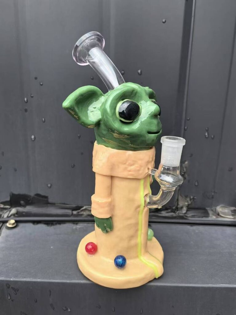 Yoda glass bong holding a small bowl with colored marbles
